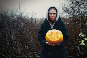 joven mujer participación el Víspera de Todos los Santos calabaza en el otoño antecedentes foto