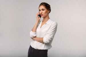 hermosa mujer de negocios con un célula teléfono en manos. grave conversación. negocio retrato foto