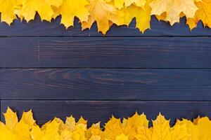 otoño hojas marco en de madera antecedentes parte superior ver otoño frontera amarillo y naranja hojas Clásico madera mesa Copiar espacio para texto. foto