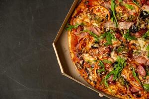 Appetizing pizza with smoked sausages bacon meat tomato cheese arugula photo