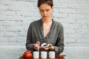 joven mujer sentado en meditación actitud en frente de té conjunto y aroma palos relajación concepto foto