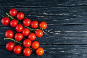 Cherry tomatoes on the dark black wooden table photo