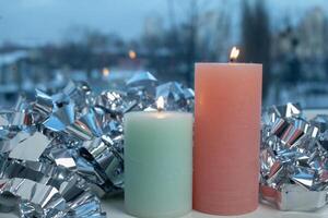 winter decor on windowsill with two candle and silver foil photo