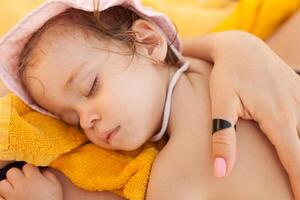 little girl in the panama on the beach sleep near the mother. family vacation. photo