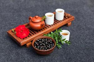 Traditional Chinese tea ceremony with black currant, fruit tea and healthy food. Photo without people. Summer natural vitamins and berries