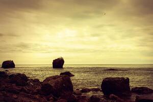 big stone in the sea and red sunset photo