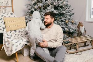 fiesta Navidad hermoso padre jugando con pequeño linda hijo cerca decorado nuevo año árbol a hogar foto