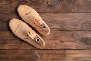 Leather samples for shoes and wooden shoe last on blue wooden table. photo