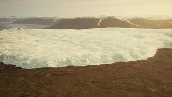 A massive iceberg floating in the serene waters of a lake video