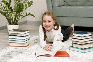 laughing girl at home on the floor surrounded by books photo