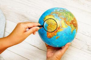 woman looking at Africa on a globe using a magnifying glass photo