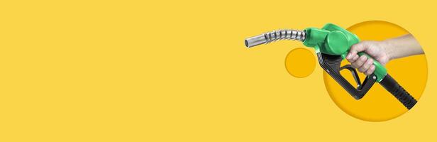 Hands holding Fuel nozzle on yellow background photo