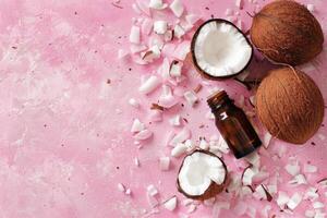 AI generated Coconut essential oil on a pastel pink background with coconuts and and coconut flakes. Copy space photo