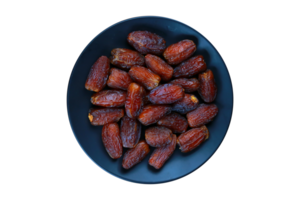 Dried date fruits on a black plate isolated on a transparent background. png