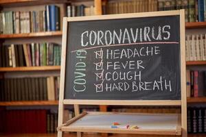 coronavirus síntomas. brote advertencia. escrito blanco tiza en pizarra en conexión con epidemia de coronavirus mundial. foto