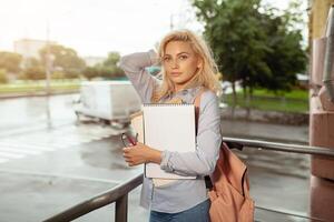 Enthusiastic Happy beautiful young girl smiling and holding pile of books standing near campus lifestyle positivity academic graduating university school photo