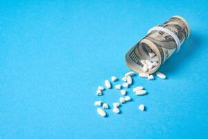 pills empty blisters for drugs individual syringe and money lie on a blue background photo