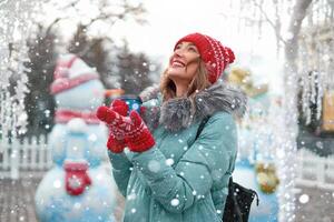 Beautiful lovely middle-aged girl with curly hair warm winter jackets stands ice rink background Town Square. photo