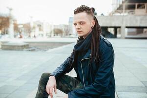 rocker rock star young man walking on the city street autumn day photo