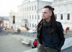 rocker rock star young man walking on the city street autumn day photo