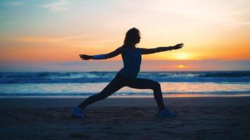 silueta mujer práctica yoga guerrero actitud a meditación con verano vacaciones playa felicidad y relajación. calma hembra ejercicio con yoga meditar Oceano playa con puesta de sol dorado tiempo. foto