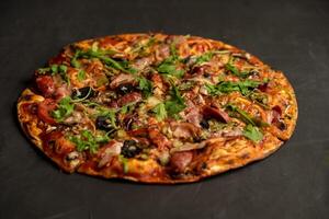 Appetizing pizza with smoked sausages bacon meat tomato cheese arugula photo