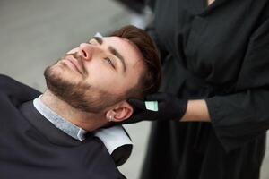 joven hermosa caucásico mujer peluquero cortes barba hermoso hombre a moderno barbería foto