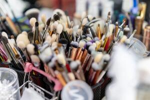 Makeup brushes there A lot of brushes randomly standing in containers at the workplace of a makeup artist or stylist. photo