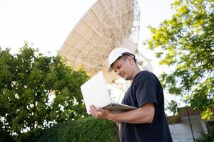 Engineer looking earth based astronomical radio telescope photo