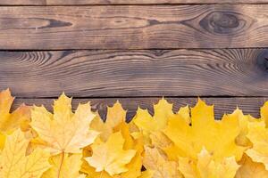 otoño hojas marco en de madera antecedentes parte superior ver otoño frontera amarillo y naranja hojas Clásico madera mesa Copiar espacio para texto. foto