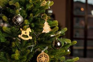 Close-up of a Christmas tree decorated with gold balls and blue bows. Christmas holiday concept photo