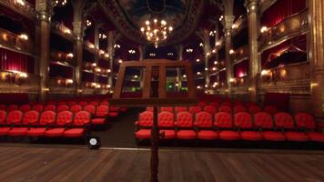 An empty theater with red seats and chandeliers video