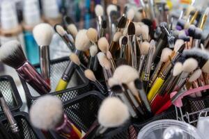 Makeup brushes there A lot of brushes randomly standing in containers at the workplace of a makeup artist or stylist. photo