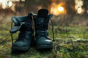 cerca arriba de Clásico par de caminando botas en roca pradera antecedentes. foto