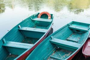 Old boat with oar near river or beautiful lake. Calm sunset on the nature. Fishing boat photo