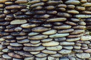 River pebble gravel round stone wall patterned for background. Gray pebbles background for home and home exterior wall and floor decoration. photo