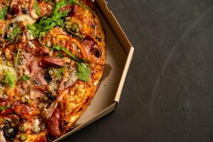 Appetizing pizza with smoked sausages bacon meat tomato cheese arugula photo