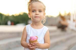 Little caucasian girl 3 years old eats ice cream closeup portrait photo