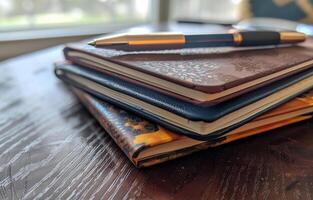 AI generated Pen and notebook on table. A stack of spiral notebooks and hardcover books with a pen on top photo