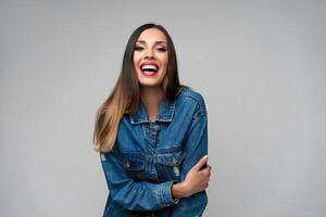 hermosa caucásico niña en un mezclilla chaqueta posando en el estudio en un blanco antecedentes. foto