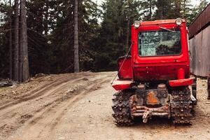 tractor bonnet and big wheels on natural soil road in spring forest photo