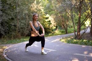 mujer corredor extensión piernas antes de hacer ejercicio verano parque Mañana foto