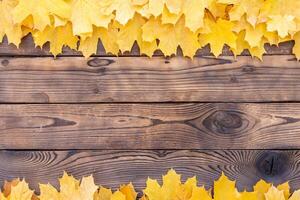 Autumn leaves frame on wooden background top view Fall Border yellow and Orange Leaves vintage wood table Copy space for text. photo