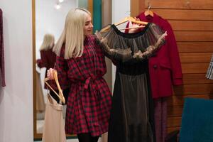 One caucasian women in a fashion boutique choose clothes buy for autumn season. photo