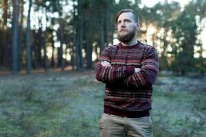 Portrait brutal bearded hipster man in the forest photo