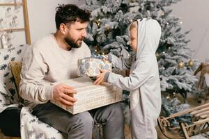 fiesta Navidad hermoso padre jugando con pequeño linda hijo cerca decorado nuevo año árbol a hogar foto