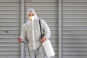 Worker wearing protective suit disinfection gear disinfect surface public place photo