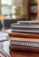 AI generated Stack of books. A stack of spiral notebooks and hardcover books with a pen on top photo