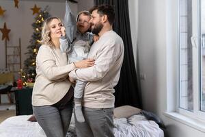 Happy family concept. Husband hug belly pregnant wife standing indoor living room near sofa photo