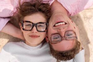 dos atractivo estudiantes vistiendo elegante lentes acostado en el piso foto